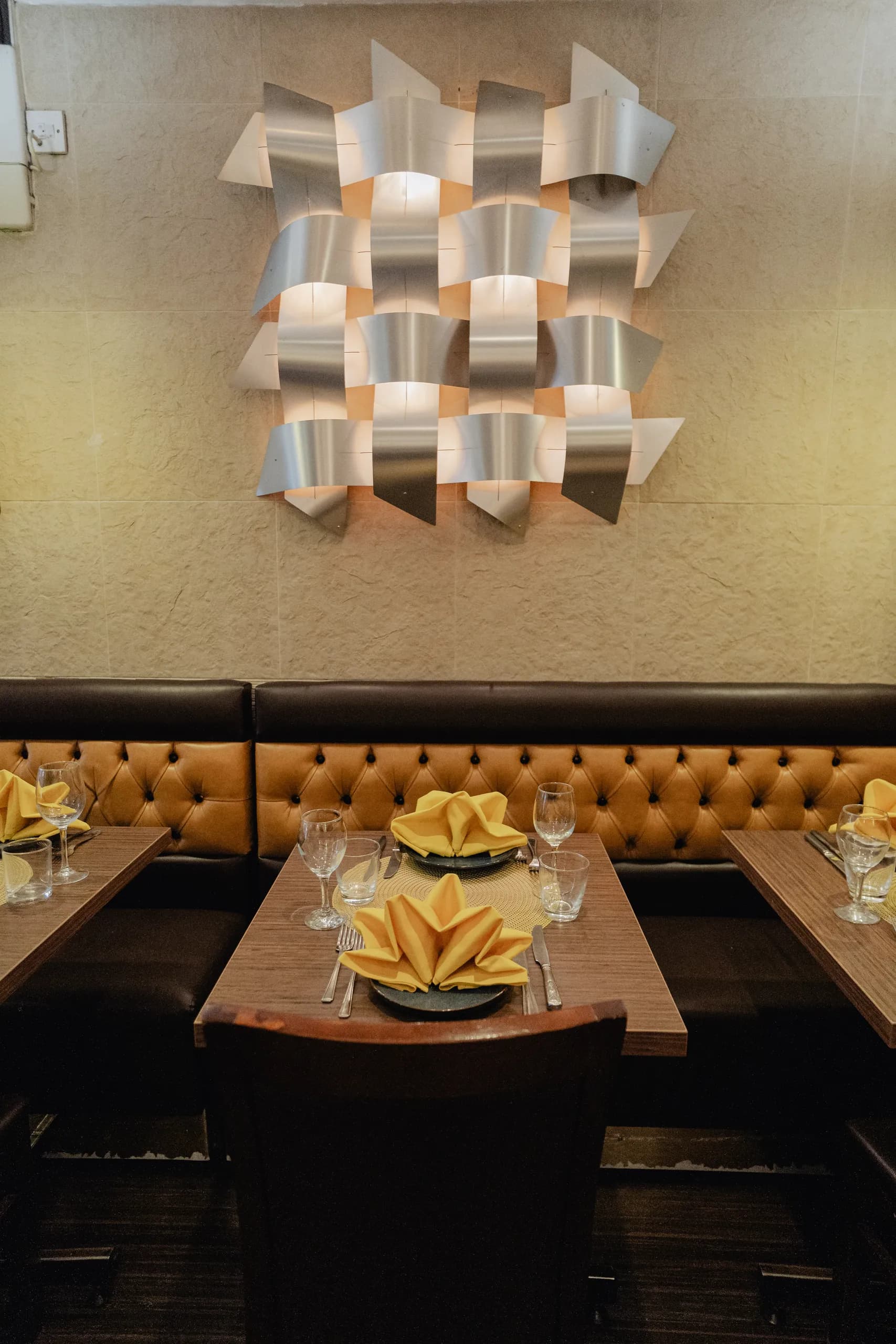 The dining room at Maharaja of India with tan leather banquettes